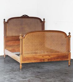 an antique bed frame with wicker headboard and foot board