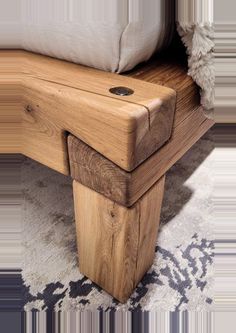 a wooden bench sitting on top of a carpeted floor next to a white pillow