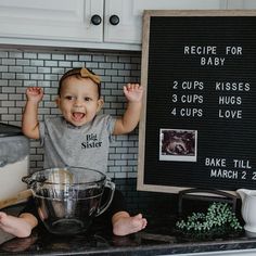 a baby standing in front of a mixing bowl with ingredients on the counter top next to a sign that says recipe for baby