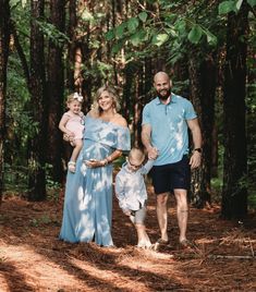 a man, woman and child are standing in the woods holding hands with each other