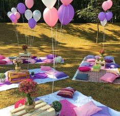 a bunch of balloons that are in the air on some blankets and rugs outside