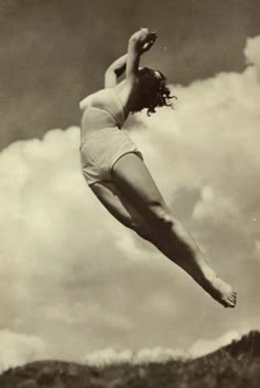 an old photo of a woman in mid air