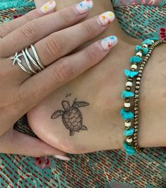 a woman's feet with tattoos and bracelets on top of her body,