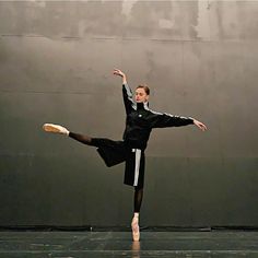 a man in black and white is doing a dance move with his legs spread out