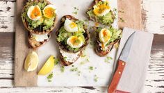 an open face sandwich with hard boiled eggs and avocado on toasted bread