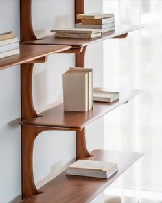 three wooden shelves with books on them