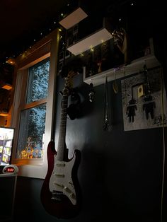 an electric guitar hanging on the wall next to a window