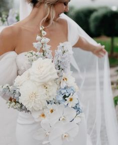 a woman in a wedding dress holding a bouquet of flowers