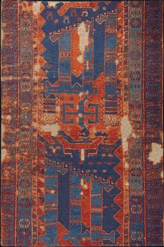 an orange and blue rug with many different designs on it's sides, including the middle