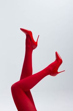 a woman's legs in red stockings and high heels