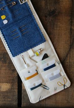 an assortment of sewing tools are displayed on a wooden surface with scissors and other items