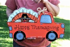 a person holding up a sign with a turkey in the truck on it that says happy thanksgiving