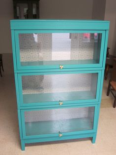 a blue dresser with glass doors and drawers