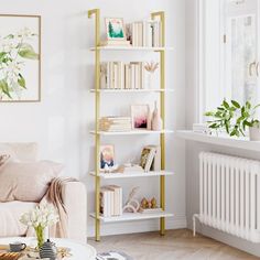 a living room filled with furniture and bookshelves in front of a white wall