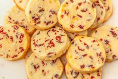 a pile of cookies sitting on top of a white plate covered in red and yellow sprinkles