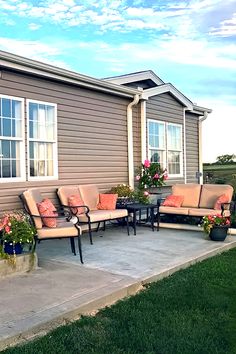 a patio with couches and chairs in front of a house