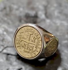 This ring is absolutely stunning and very unique.  The band is solid sterling silver,  and the center, and two side coins are made from the silver bars recovered from the Atocha and comes with a certificate stating that. I use a 14kt gold plating on the coins to give this piece a striking contrast. Bronze 14k Gold Ring, 14k Gold Bronze Ring Jewelry, Silver 14k Gold Ring For Commemoration, 14k Gold Coin Jewelry Stamped 14k, Polished Bronze Ring Jewelry, Heirloom Signet Ring For Commemoration, Heirloom Round Signet Ring For Commemoration, Classic Collectible Coin Rings, Silver 14k Gold Signet Ring For Commemoration