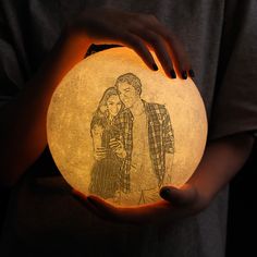 a person holding a light up with a drawing on it