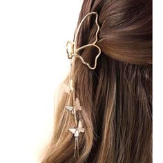 a woman with long brown hair wearing a gold butterfly hair clip and dangling earring