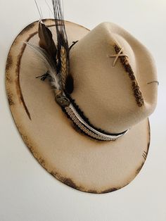 Rustic Fedora With Flat Brim For Festivals, Rustic Flat Brim Fedora For Festivals, Handmade Adjustable Rustic Fedora, Rustic Adjustable Distressed Hat Bands, Rustic Distressed Hat With Flat Brim, Festival Flat Brim Hat With Feather Trim, Artisan Hats With Feathers And Adjustable Fit, Distressed Bohemian Hat Band For Festivals, Distressed Bohemian Hat Bands For Festivals