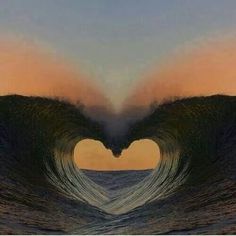 a heart shaped wave in the ocean at sunset