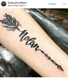 a tattoo with the word mama written in cursive writing and an arrow on it