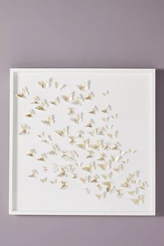 a white tray with gold butterflies on the bottom and one in the middle, against a purple wall