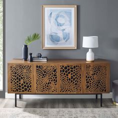 a living room with a painting on the wall next to a sideboard and lamp