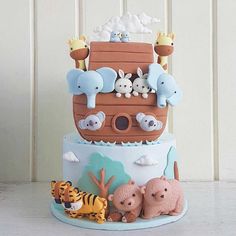 a three tiered cake decorated with animals and a noah's ark on top