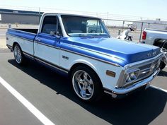 a blue and white truck parked in a parking lot