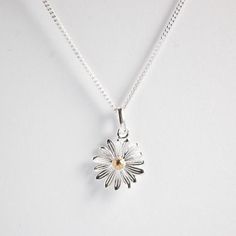 A beautifully designed 925 Sterling Silver Daisy Pendant with a Gold Plate stamen in the centre. The daisy is the April birth flower but also represents innocence, purity and new beginnings, which is why they are often gifted to new mothers or as gift for children.Choose which chain length you would prefer from the drop down menu. A lovely gift for family or friends or maybe something nice for yourself.Your purchase will arrive in a organza gift pouch but if you would like a luxury ribboned box, Sterling Silver Daisy Jewelry With Flower Charm, Sterling Silver Daisy Flower Charm Jewelry, Flower Necklace Silver, April Birth Flower, Daisy Pendant, Silver Flower Necklace, Flower Daisy, Daisy Necklace, Necklace Flower