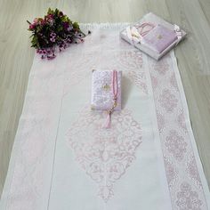 pink and white table cloths on the floor with flowers next to them, along with other items