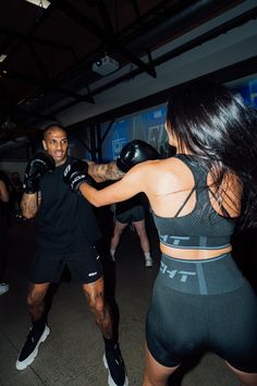 a man and woman in boxing gear standing next to each other