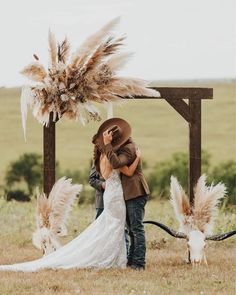 a bride and groom kissing in front of an animal skull