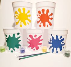 four buckets with paint and brushes on them