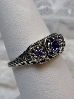 Art deco style ring with three Purple amethyst CZs set in sterling silver filigree Classic Amethyst Ring With Accent Stones In Cubic Zirconia, Classic Amethyst Ring With Cubic Zirconia Accent Stones, Classic Amethyst Ring With Accent Stones, Classic Purple Jewelry For Promise, Classic Amethyst Cubic Zirconia Promise Ring, Classic Amethyst Ring With Cubic Zirconia For Gift, Classic Cubic Zirconia Amethyst Ring For Gift, Sterling Silver Jewelry With Intricate Design In Purple, Sterling Silver Purple Jewelry With Intricate Design