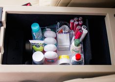 the inside of an airplane compartment filled with cosmetics and hygiene products, including toothbrushes