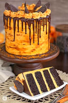 a chocolate cake with orange icing and cookies on top is sitting on a table