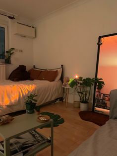 a bedroom with a bed, couch and table in it next to a large window