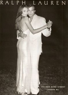 a black and white photo of a man and woman in formal wear hugging each other