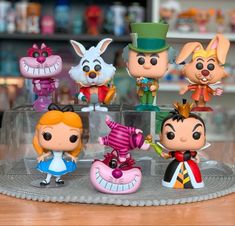 the figurines have been placed on top of a glass plate with an image of alice