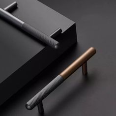 a pen sitting on top of a table next to a black box and metal object