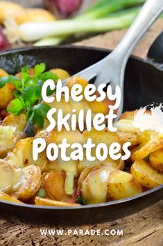 a skillet filled with potatoes and cheese on top of a wooden table next to vegetables