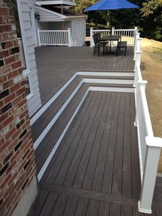 a deck with white railings and an umbrella