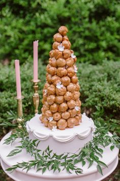 a wedding cake made out of donuts on top of a white plate with greenery