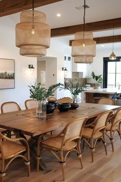 a dining room table with chairs and lights hanging from the ceiling