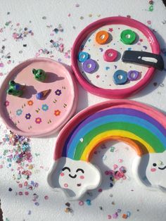 there are three plastic plates with different designs on them, one has a rainbow and the other has sprinkles