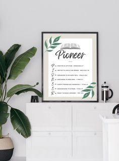 a poster with the words pioneers on it next to a potted plant in a white room