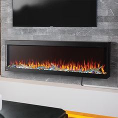 an electric fireplace in a living room next to a flat screen tv on the wall