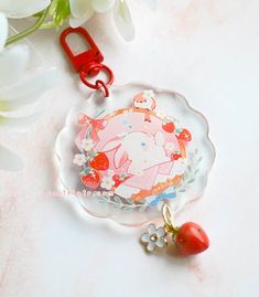 a glass plate with a strawberry charm attached to it